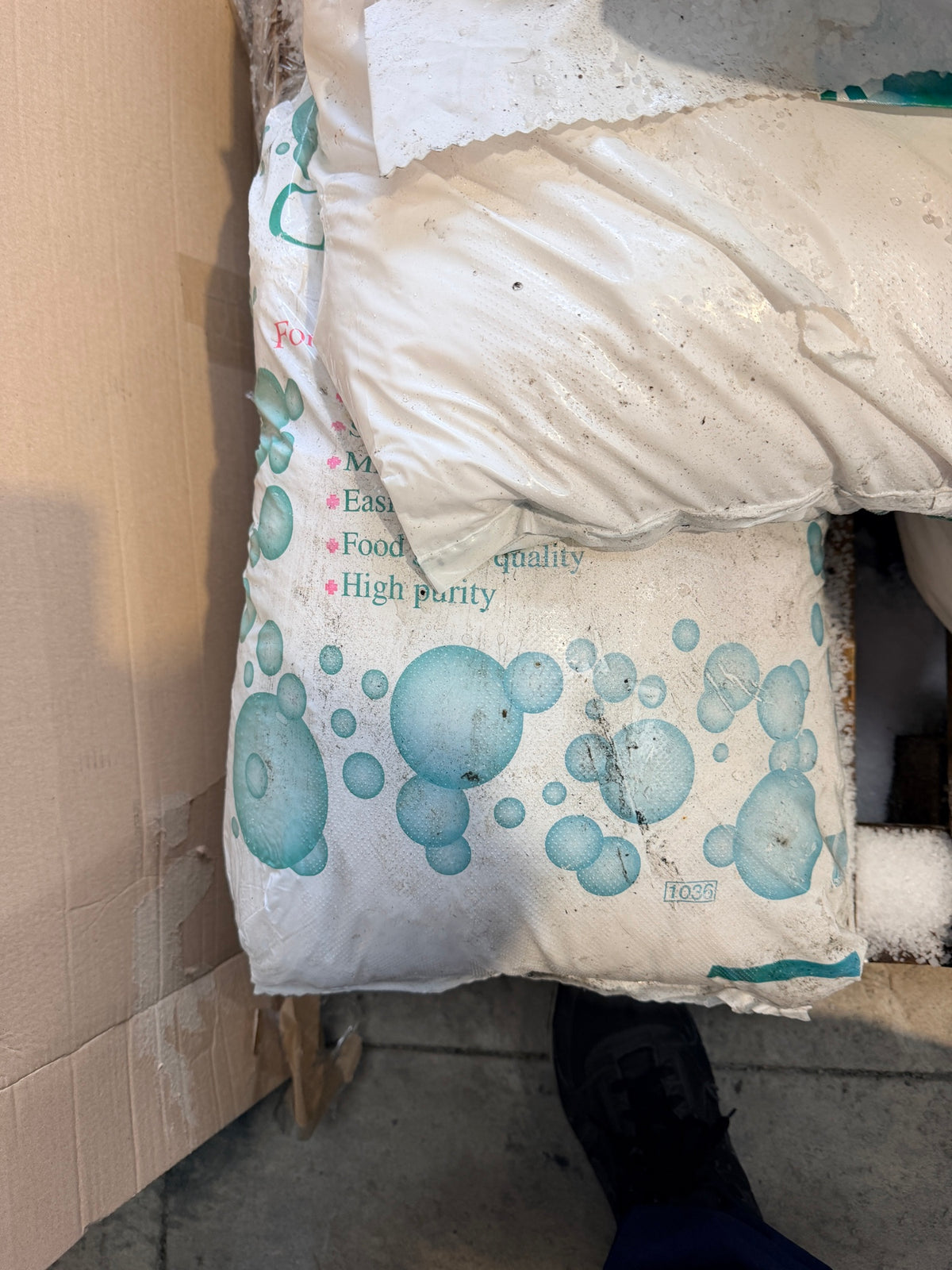 Split bag on the pallet showing loose salt