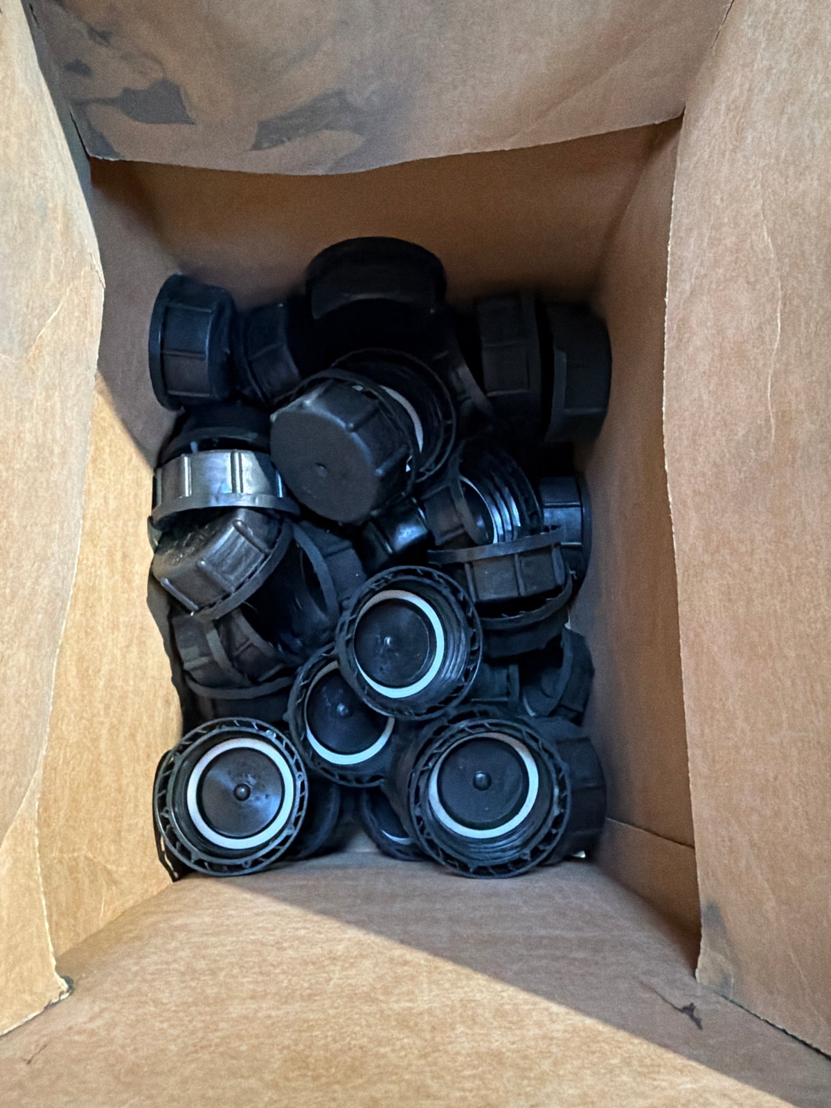 Box of black screw caps for the 20L jerry cans