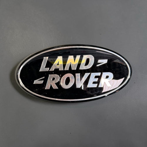 Land Rover oval badge, black and silver with chrome surround, top view
