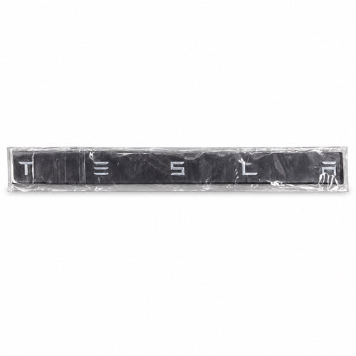 Silver-coloured aftermarket Tesla lettering set in protective packaging